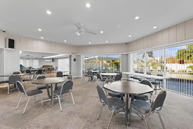 carpeted dining space with ceiling fan