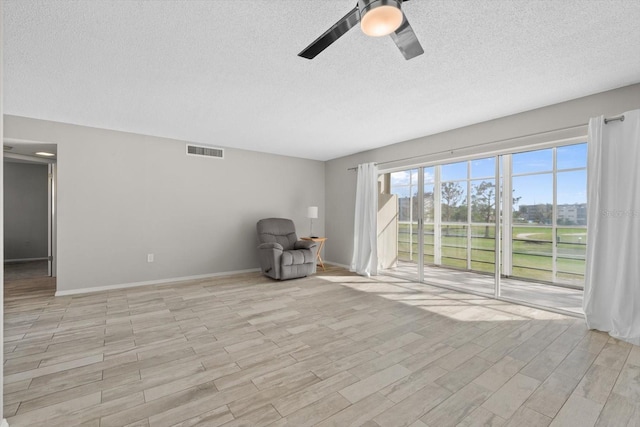 unfurnished room featuring a textured ceiling, light hardwood / wood-style floors, and ceiling fan