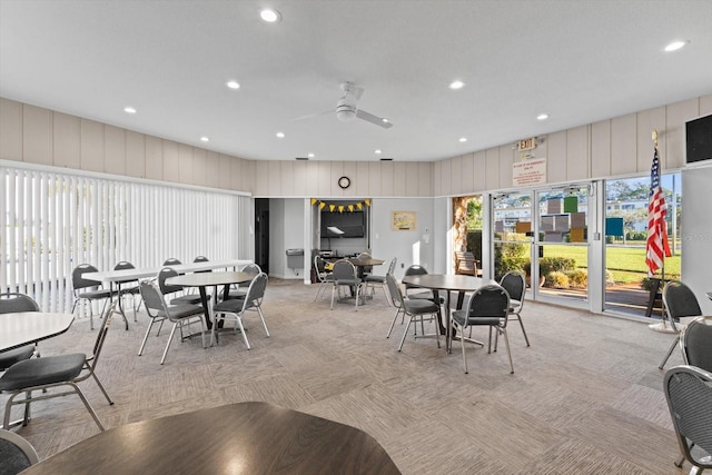 carpeted dining space with ceiling fan