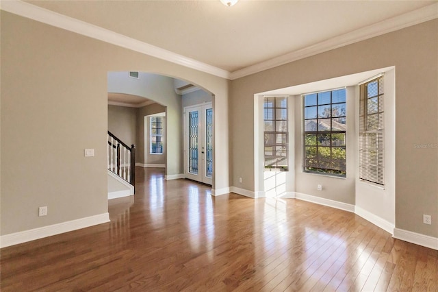 empty room with french doors, ornamental molding, and hardwood / wood-style flooring