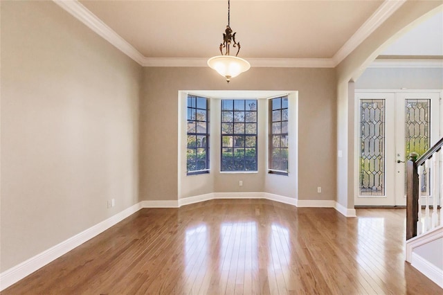 foyer entrance with hardwood / wood-style flooring, ornamental molding, and french doors