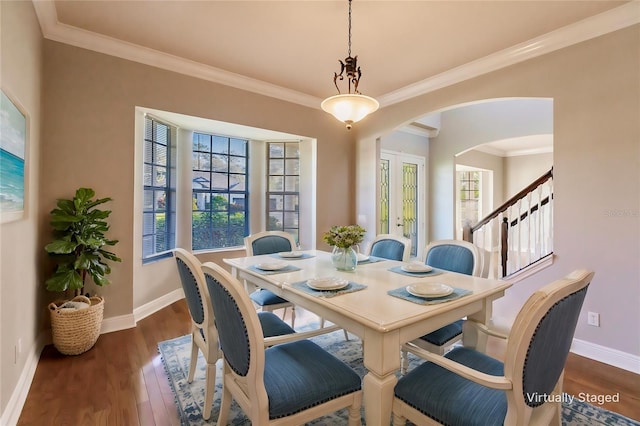 dining space with dark hardwood / wood-style flooring and crown molding