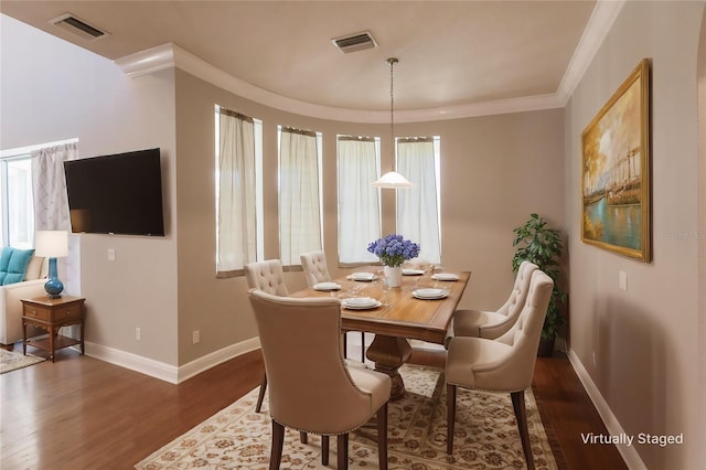 dining area featuring dark hardwood / wood-style flooring and ornamental molding