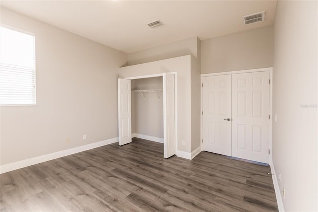 unfurnished bedroom with dark hardwood / wood-style flooring