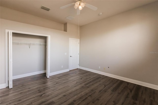 unfurnished bedroom with ceiling fan, dark wood-type flooring, and a closet