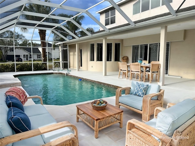 view of pool with outdoor lounge area, glass enclosure, and a patio area