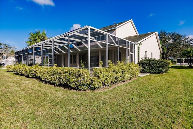 rear view of house with a lanai and a lawn