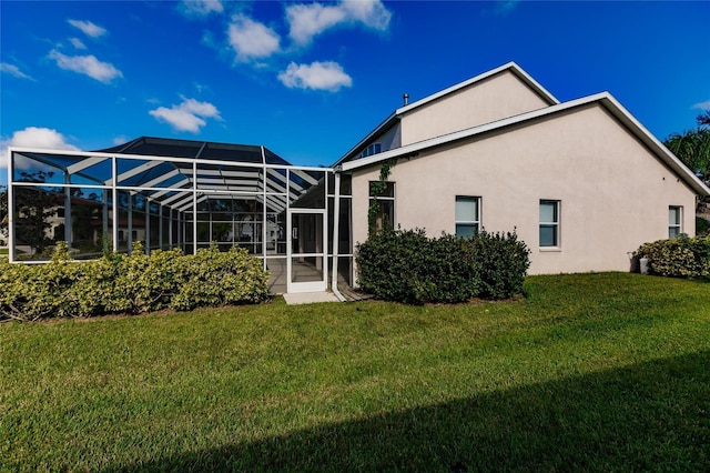 back of property featuring a yard and glass enclosure