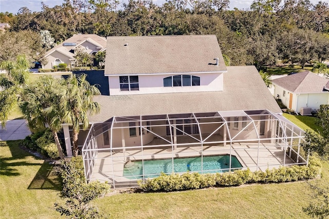 rear view of house featuring a lawn, a lanai, central air condition unit, and a patio