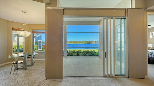 doorway with tile patterned flooring and a water view