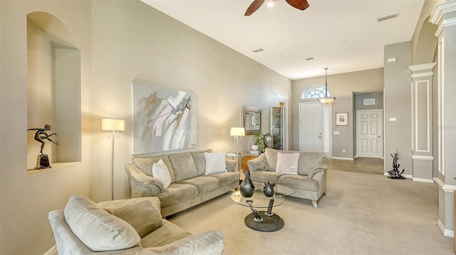 carpeted living room featuring ceiling fan and a high ceiling