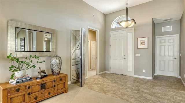 entryway featuring light tile patterned floors and a high ceiling