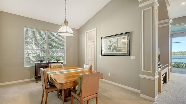 dining area with ornate columns, light carpet, and vaulted ceiling