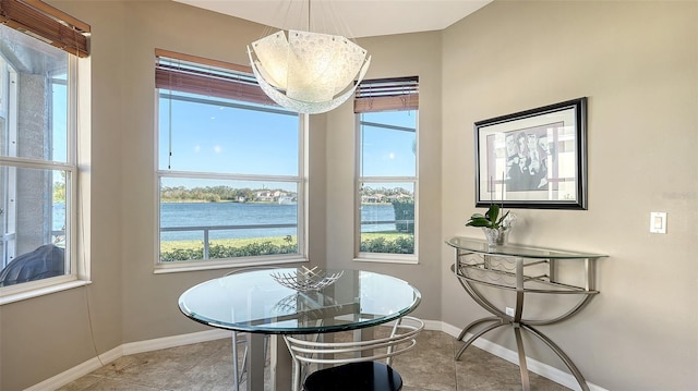 dining area featuring a water view and light tile patterned floors