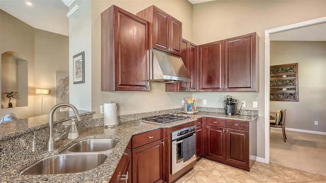 kitchen with stainless steel appliances, vaulted ceiling, sink, dark stone countertops, and light tile patterned flooring