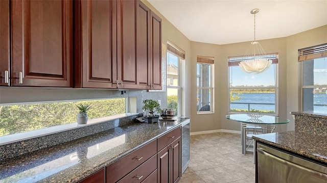 kitchen with pendant lighting, plenty of natural light, dark stone countertops, and stainless steel dishwasher