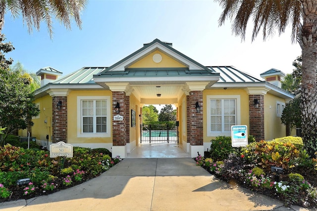 7407 Sea Island Ln, Bradenton, FL 34201 - property entrance featuring a standing seam roof, metal roof, stucco siding, and brick siding