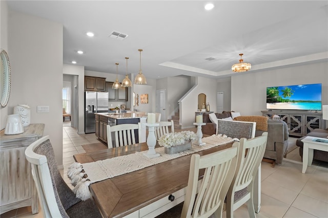 dining space featuring sink, a notable chandelier, and light tile patterned flooring