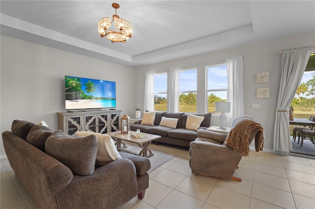 tiled living room with a tray ceiling and a notable chandelier