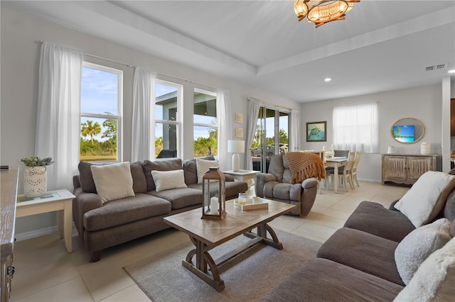 living room featuring plenty of natural light, light tile patterned floors, and a chandelier