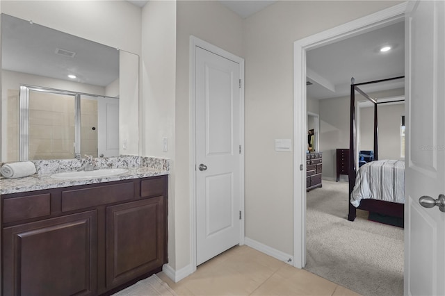 bathroom with tile patterned floors, a shower with door, and vanity