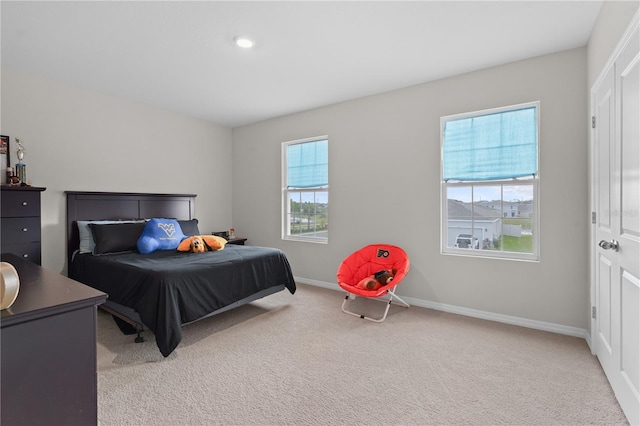 carpeted bedroom featuring multiple windows