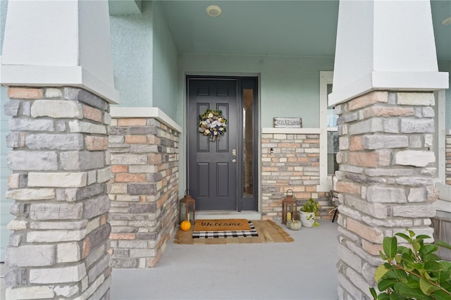 property entrance with stone siding and stucco siding