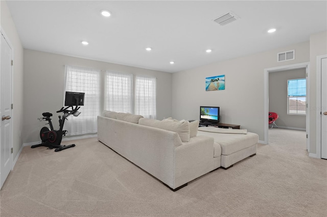 living area with light carpet, visible vents, and recessed lighting