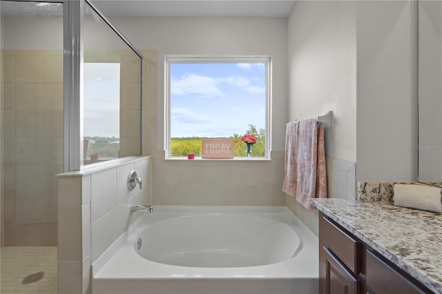 full bathroom featuring a shower stall, a bath, and vanity