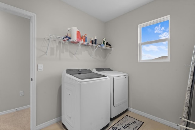 washroom with laundry area, light tile patterned flooring, baseboards, and independent washer and dryer