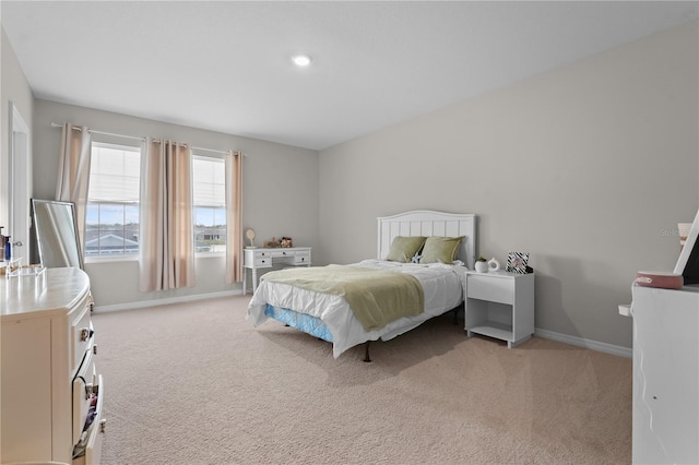 bedroom with baseboards and light colored carpet