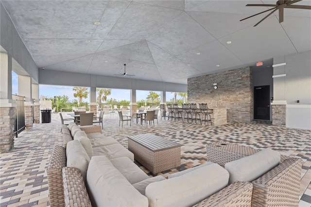 interior space with exterior bar, outdoor lounge area, and a ceiling fan