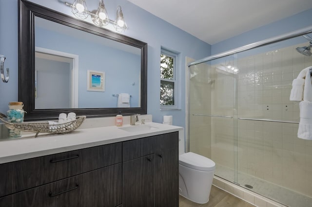 bathroom featuring vanity, toilet, a shower with door, and hardwood / wood-style floors