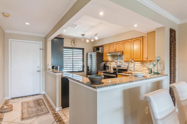 kitchen with light tile patterned floors, light stone countertops, kitchen peninsula, and appliances with stainless steel finishes