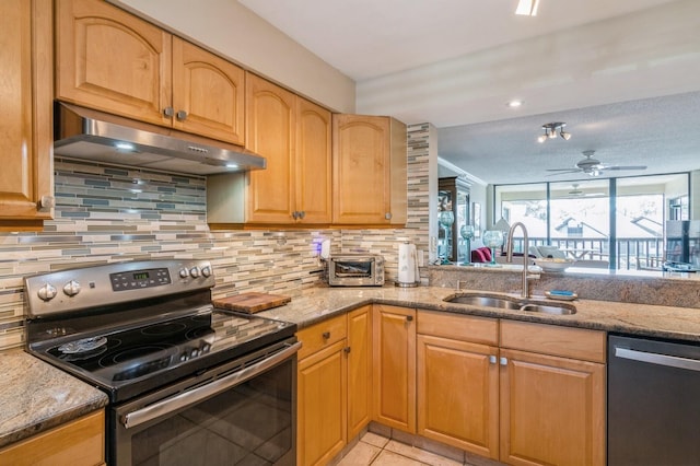 kitchen featuring light stone countertops, sink, ceiling fan, light tile patterned flooring, and appliances with stainless steel finishes