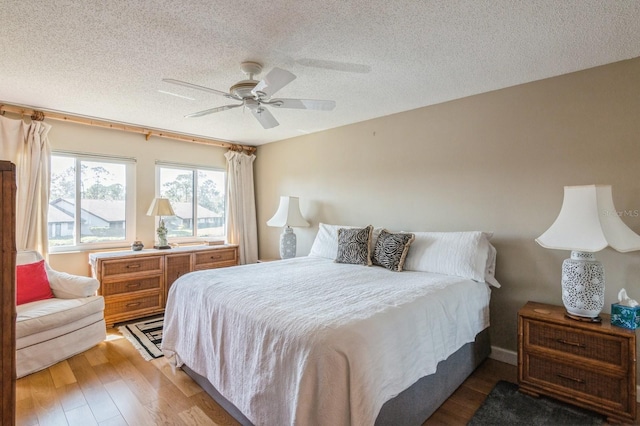 bedroom with wood-type flooring, a textured ceiling, and ceiling fan