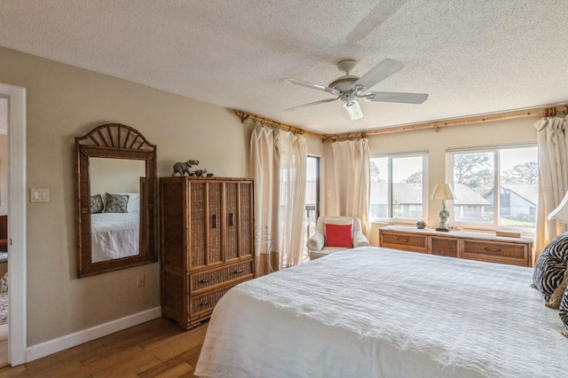 bedroom with ceiling fan, a textured ceiling, and hardwood / wood-style flooring