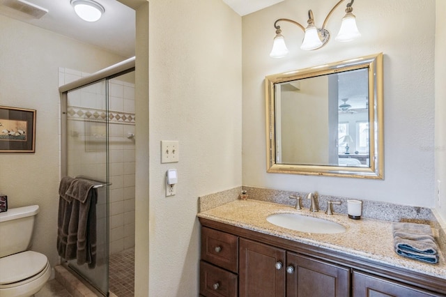 bathroom with vanity, toilet, and a shower with shower door