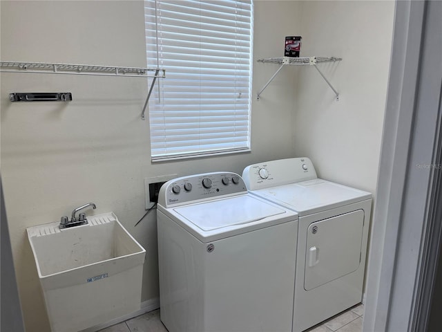 clothes washing area featuring light tile patterned floors, sink, and washer and dryer