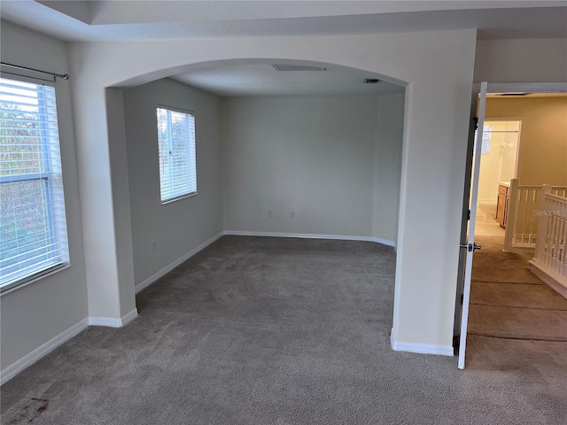 spare room featuring dark colored carpet