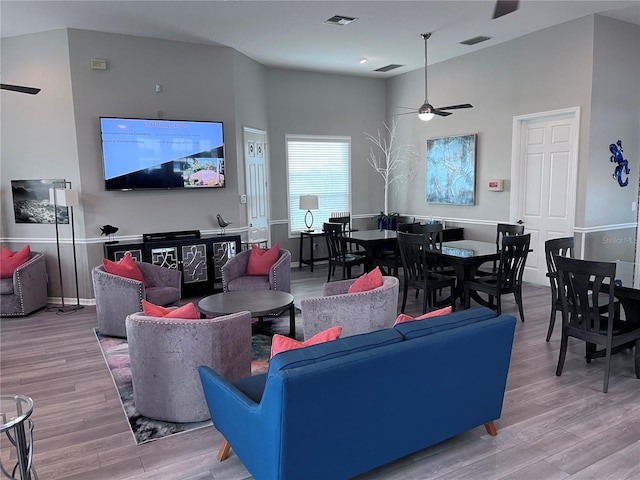 living room with light hardwood / wood-style floors and ceiling fan