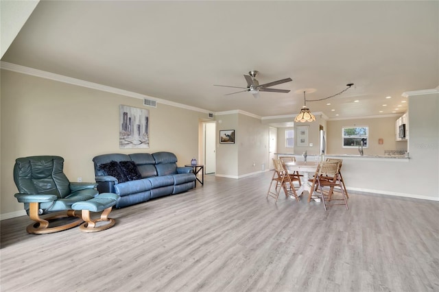 living room featuring crown molding, light hardwood / wood-style flooring, and ceiling fan