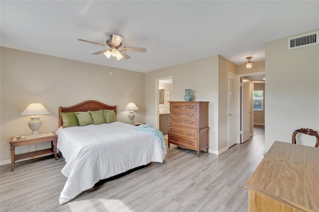 bedroom with a closet, light hardwood / wood-style floors, ensuite bath, and ceiling fan