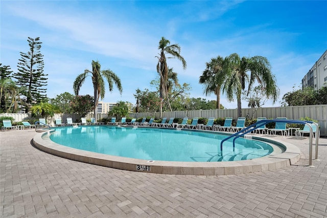 community pool with fence and a patio