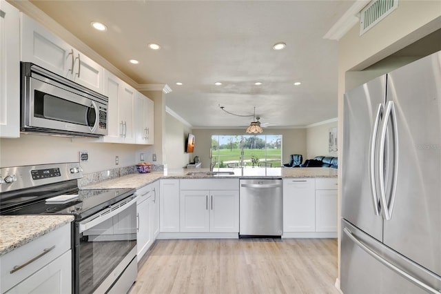kitchen featuring white cabinetry, ornamental molding, visible vents, and stainless steel appliances