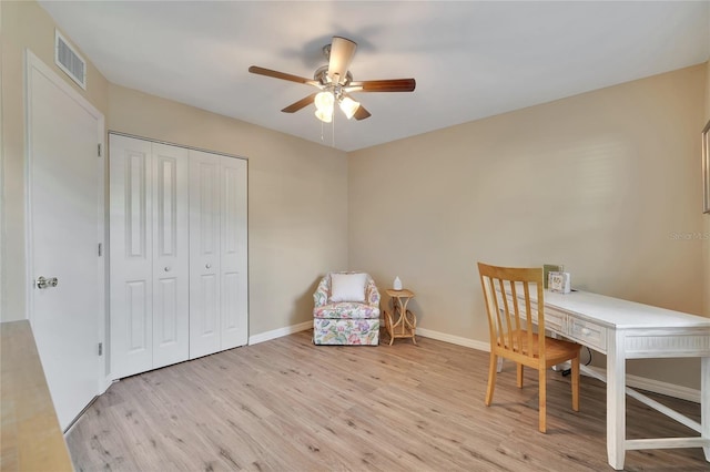 unfurnished office with light wood finished floors, baseboards, visible vents, and a ceiling fan