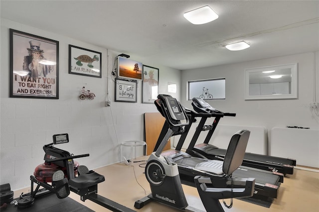 exercise room featuring concrete block wall