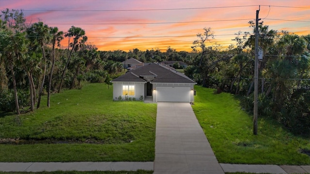 view of front of house featuring a yard and a garage