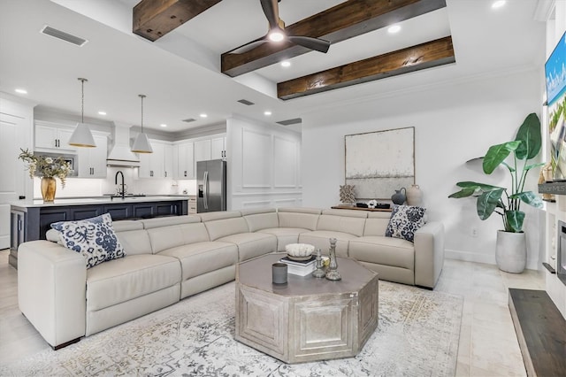 living room featuring beamed ceiling and sink