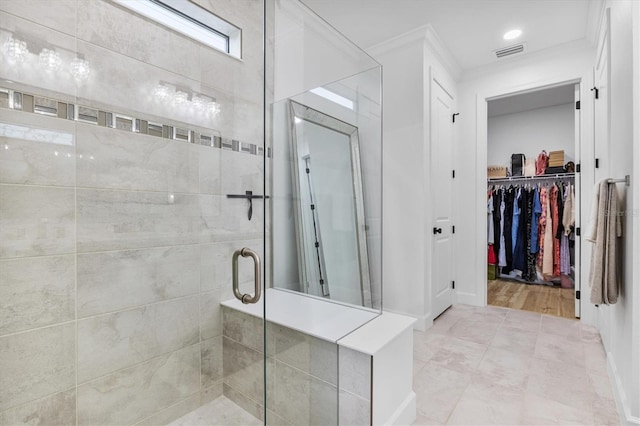 bathroom featuring hardwood / wood-style floors, a shower with shower door, and ornamental molding